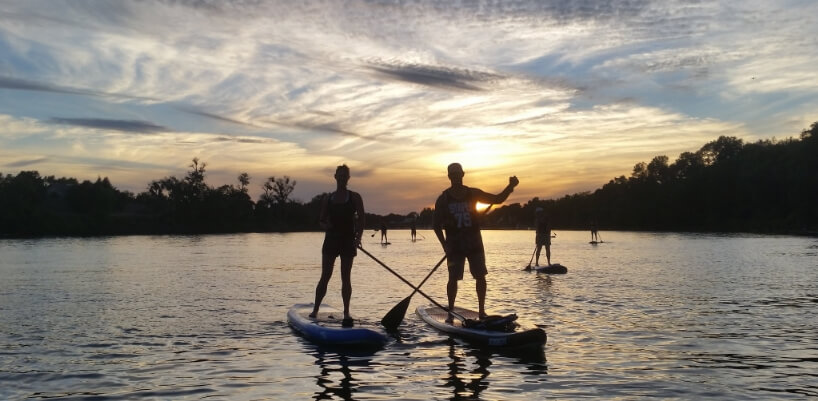 Two people stand up paddleboarding on the Sacramento River