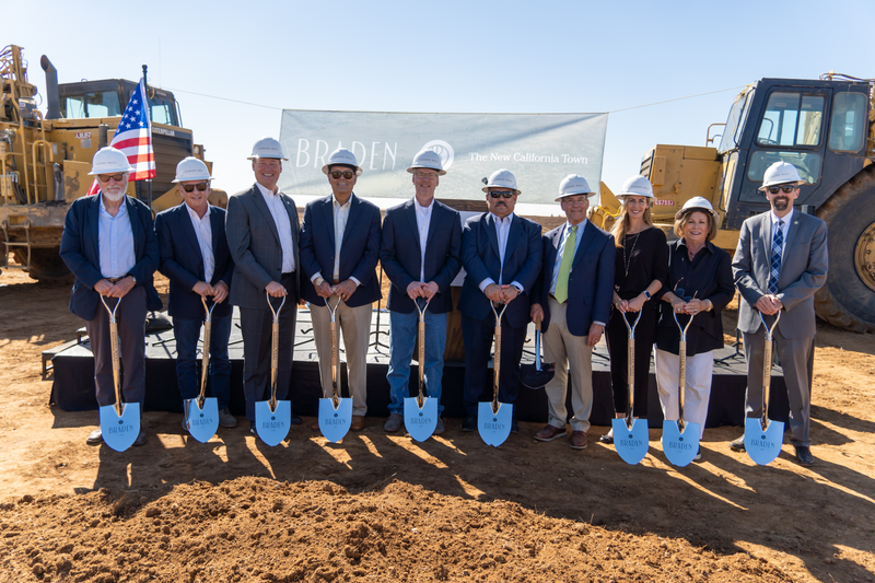 The Braden team holding shovels in front of tractors at the Braden Groundbreaking event